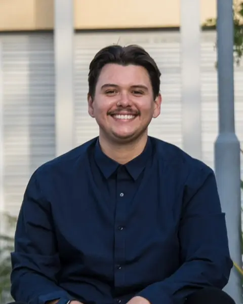 Anthony, smiling, in a navy button-up shirt